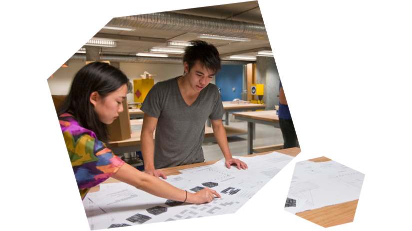 Two students looking at fabrication plans in workshop