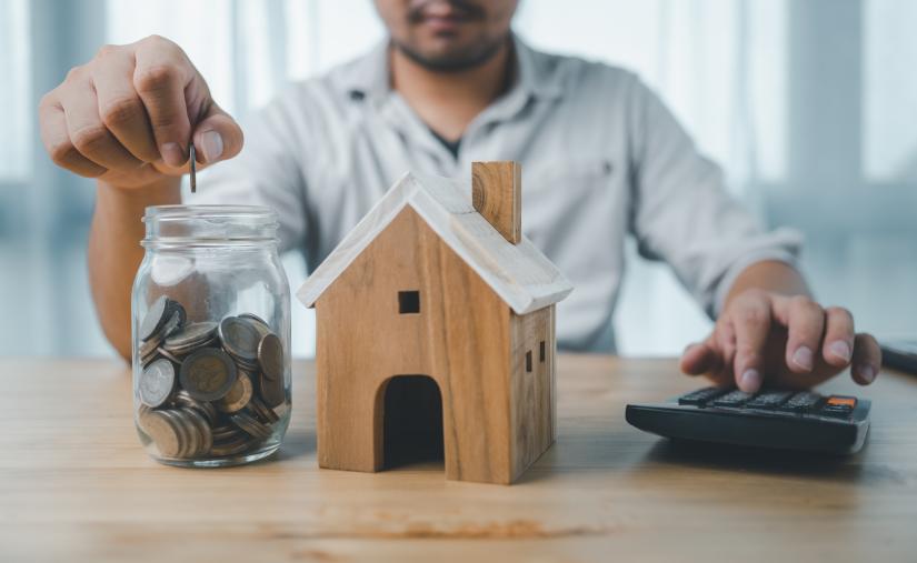 man saves money in a jar for a house