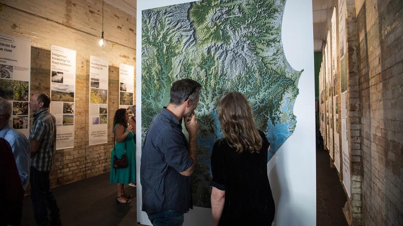 Two people looking at artwork on a wall