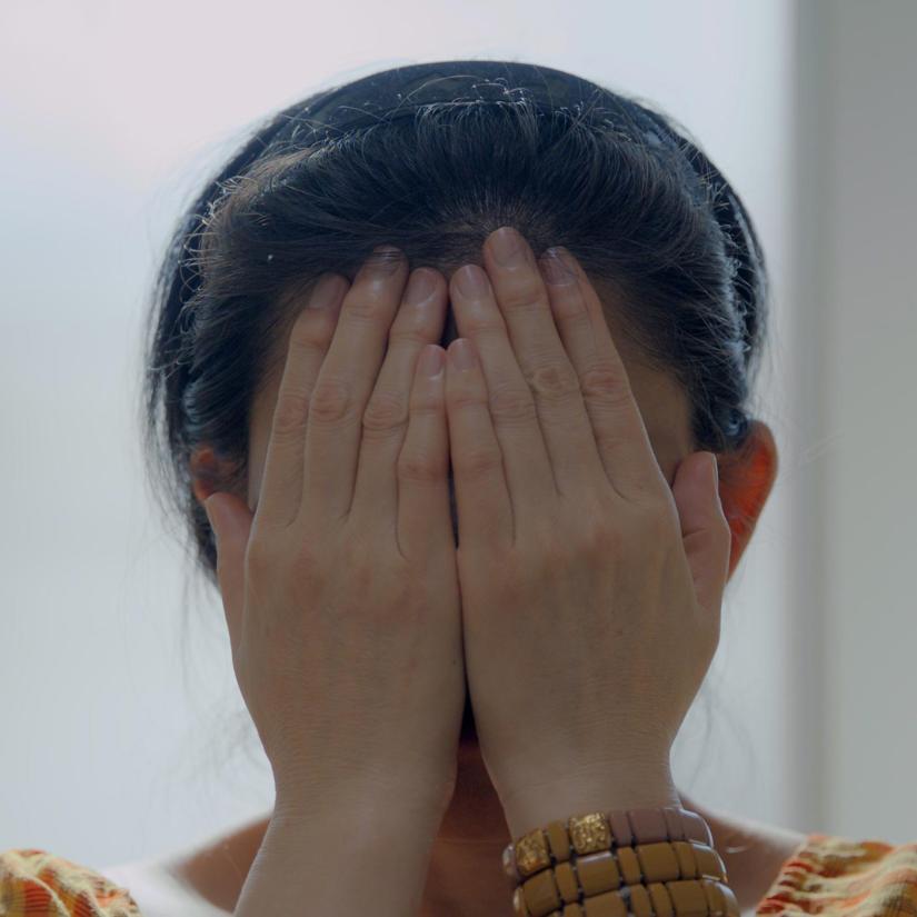 A person with hands over their face