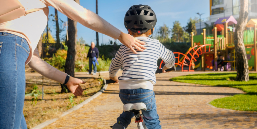 Kid learning to ride a bike in urban area