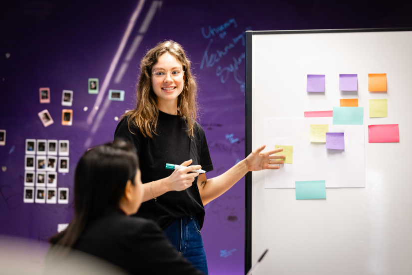 ISF PhD student Sarah Wilson presenting in front of a white board.