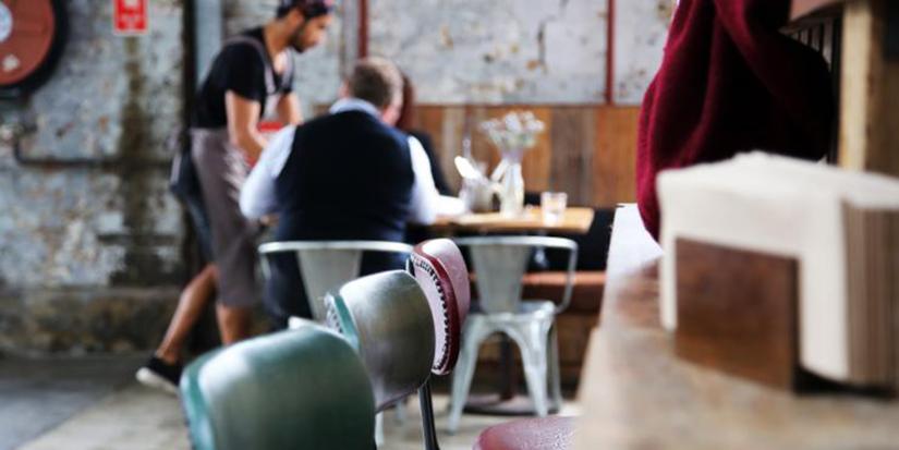 Empty cafe chairs with customers being served in the background