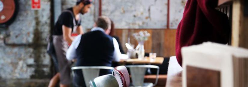 Empty cafe chairs with customers being served in the background