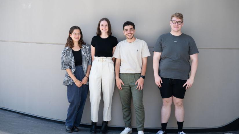 Four students standing together outside