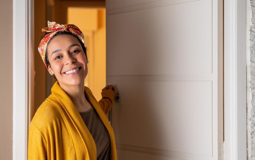 Stock image of a close up of smiling woman with head band leaving home during the day.