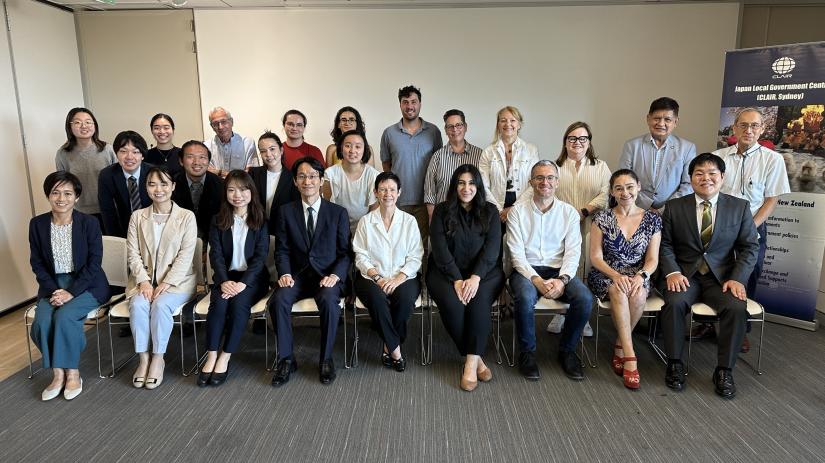 A photo from the 2024 CLAIR Forum showing a group of 24 people from the Japan Local Government Centre and UTS IPPG arranged in three rows (one sitting, two standing)