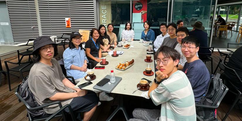 Students gathered at a long table with coffees