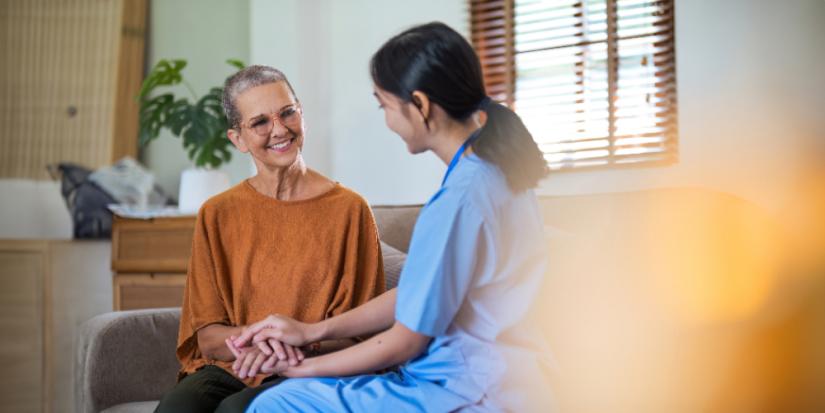 Caregiver holding hands with patient. Adobe Stock.