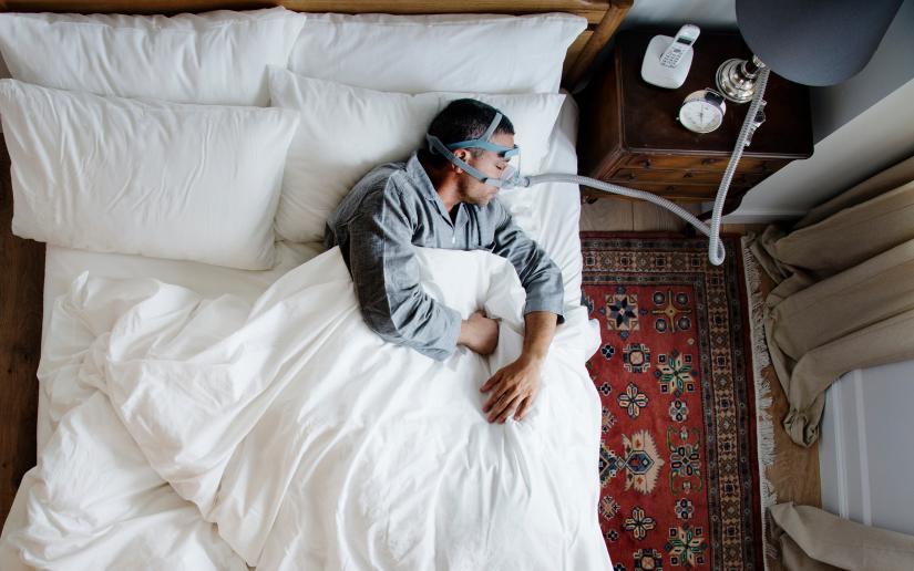 Man sleeping connected to a CPAP machine. 