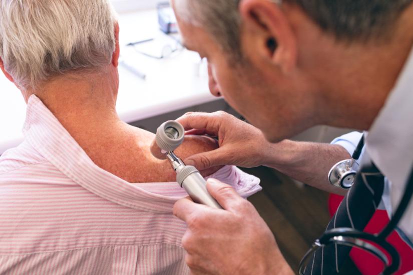 Dermatologist examining patient. Adobe Stock