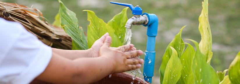 Child washing their hands under a tap