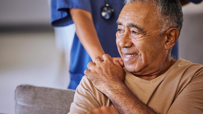 A person touches the shoulder of an old man