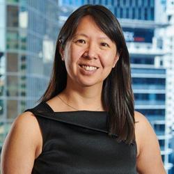 Woman in black business dress smiling and looking at the camera with long dark hair