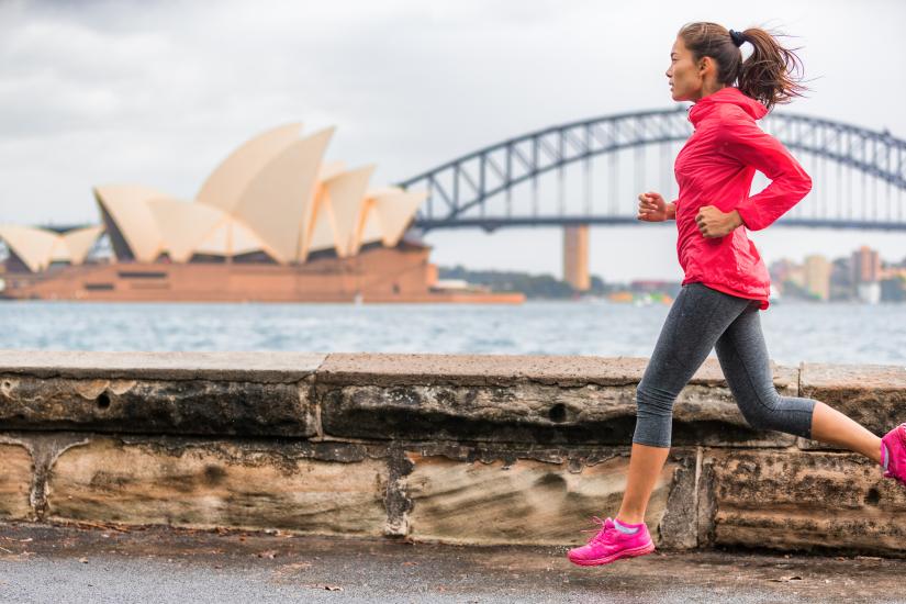 woman running past Sydney harbour. Adobe Stock