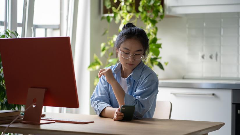 Student distracted scrolling on phone whilst studying_web