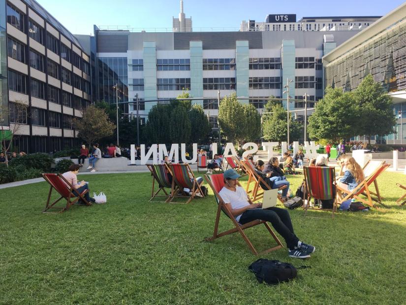 Students relaxing on the deck chairs at UTS Alumni Green