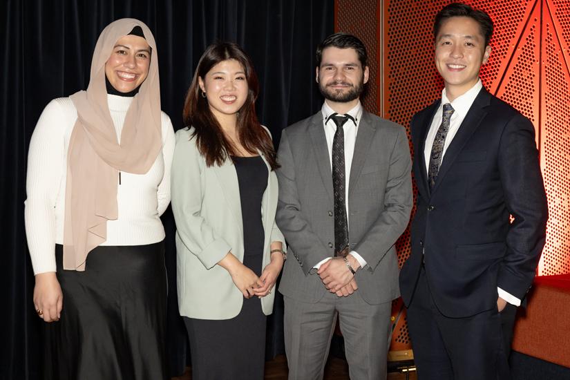 Young alumni standing and smiling looking at the camera