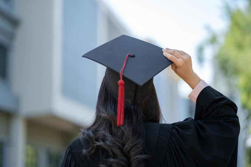 back view of a student in graduation gown and hat