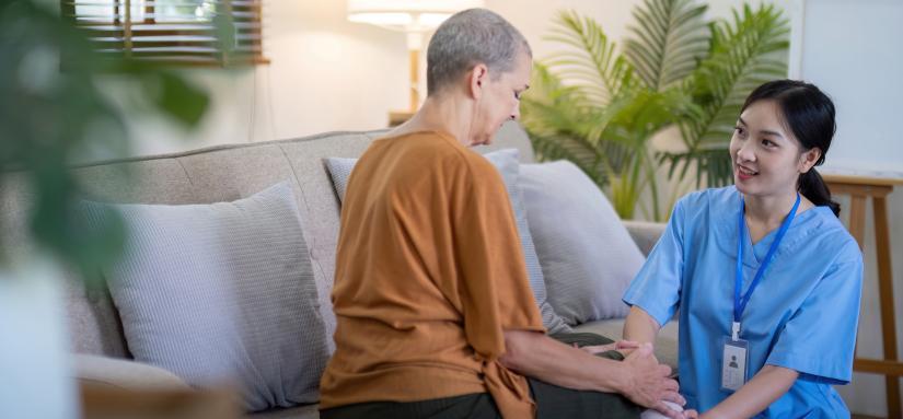 Image of a young migrant worker caring for an elderly lady