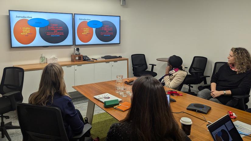 Dr Sarah Yeo and other participants looking at presentation screen