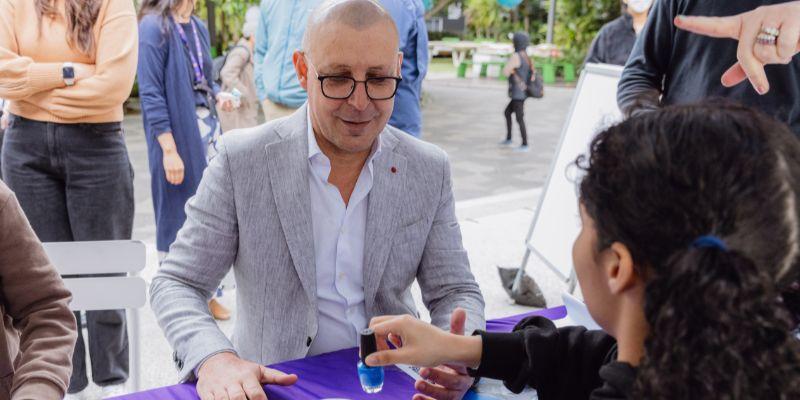 Man in a suit getting his nail painted