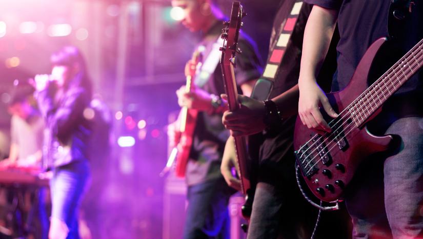 Singer and guitarists on stage. Adobe Stock