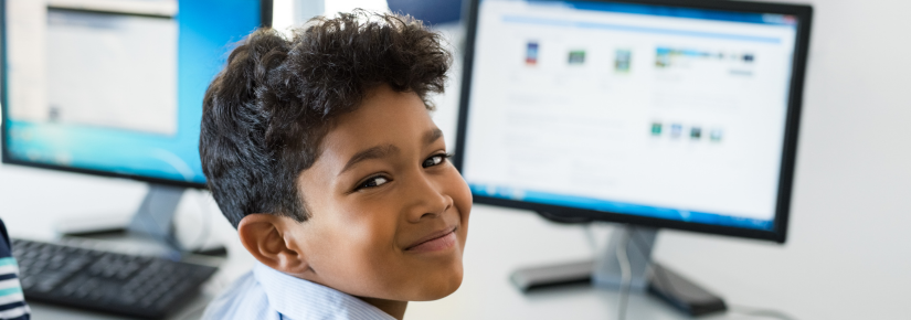 Young school boy in front of a computer.