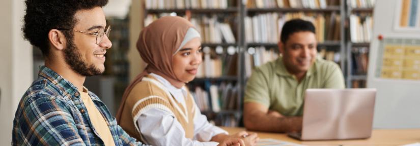 Migrant students studying together at a table. Adobe Stock By AnnaStills