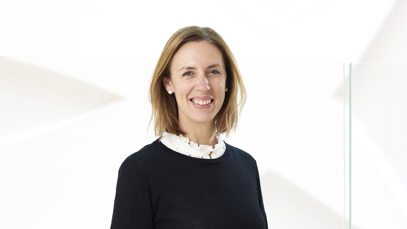 Celia Marston is smiling. She is wearing a navy jumper over a white collared shirt.