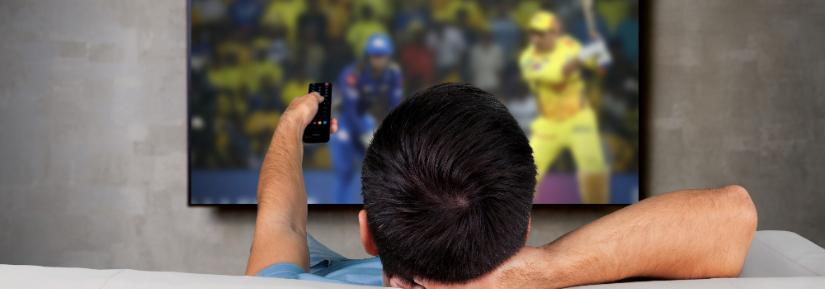 man watching cricket on TV