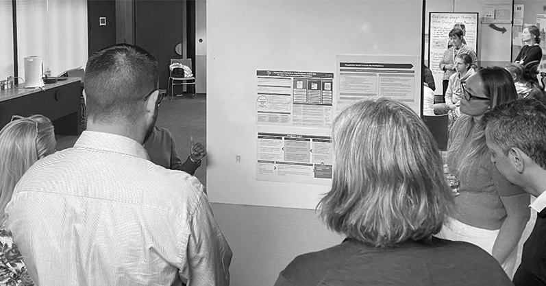 A group of people viewing a presentation from the ACT Evidence and Evaluation Academy.