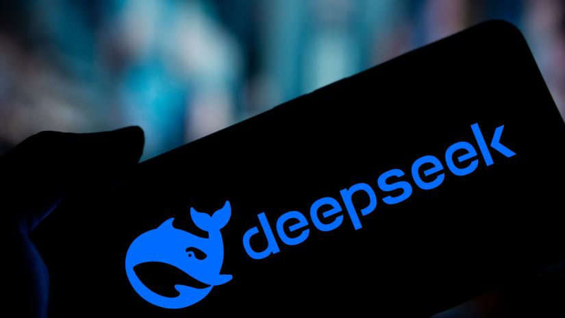 Stock picture of a hand holding a device displaying the DeepSeek name and logo