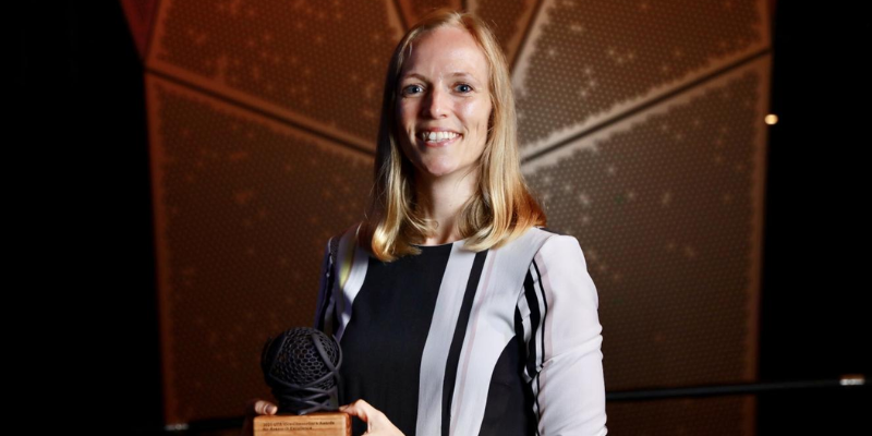 women smiling with award trophy