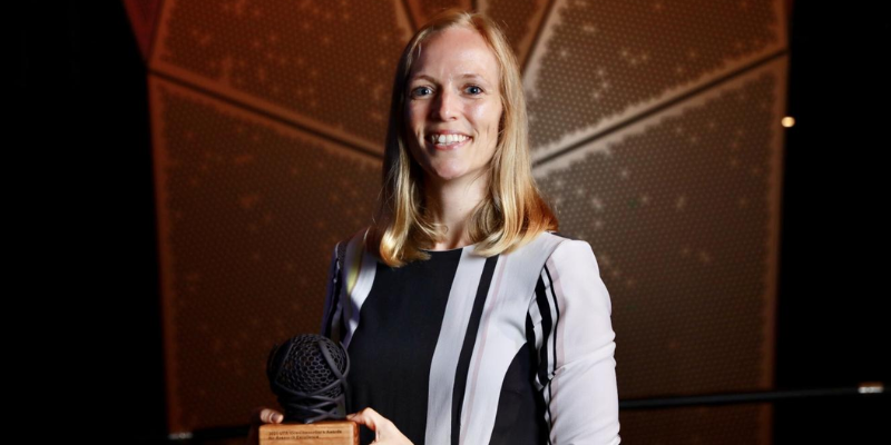 women smiling with award trophy 