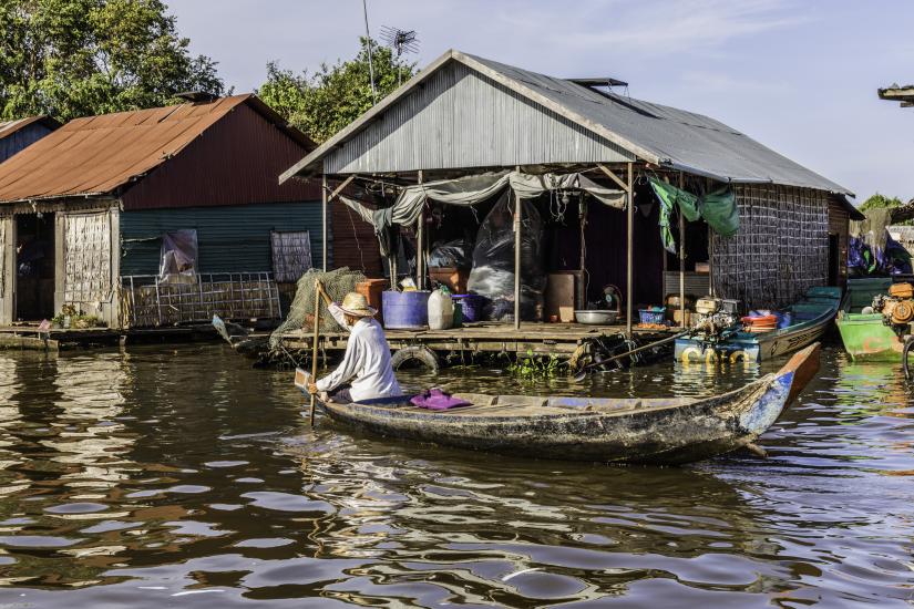 A Cambodian man is paddling home after visiting friends. Mechrey Floating Village, Seam Reap, Cambodia.