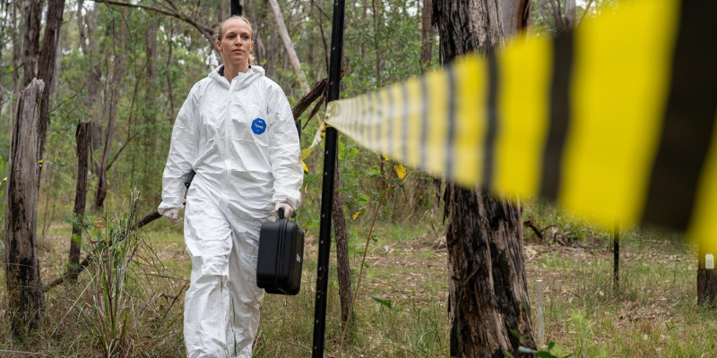 women walking along the tape of a crime scene 