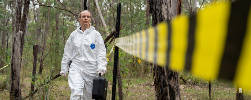 woman walking along sealed off crime scene