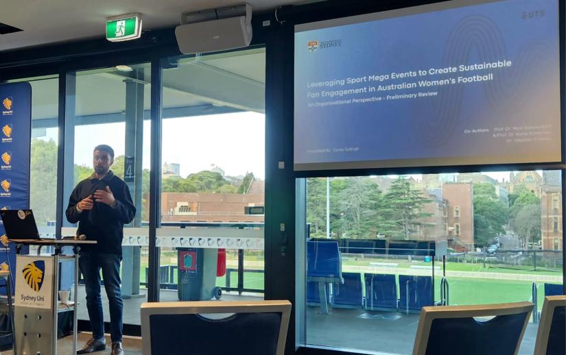 Corey Cutrupi presenting his research at a conference to promote the 2023 Women's World Cup