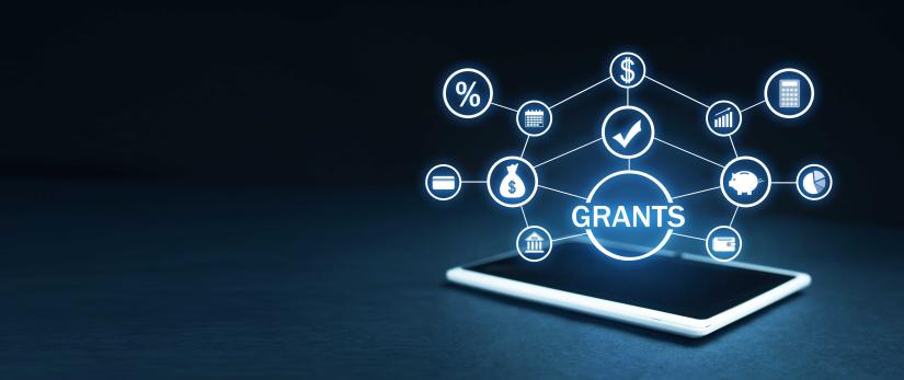 Financial icons merging from an iPad centred around the word 'Grants'