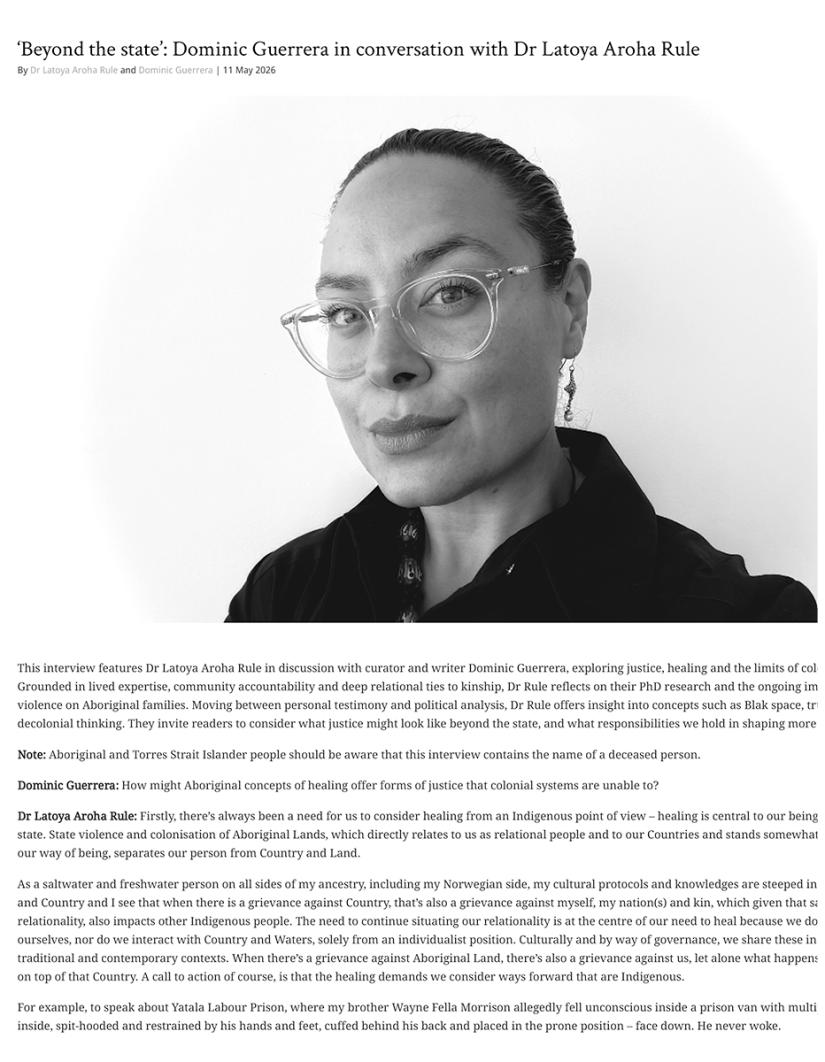 A woman with glasses and long hair tied back, wearing a dark top, looks confidently at the camera. She's part of a discussion on justice and healing.