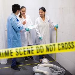 Three students in mock crime scene