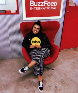 Isha sitting on a red chair in the BuzzFeed office