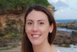 Close-up of Emma Camp with a beach and rockpool in the background