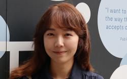 Photo of Sejeong Kim in front of a UTS mural