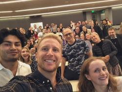 Hamish Macdonald taking a selfie in front of an audience