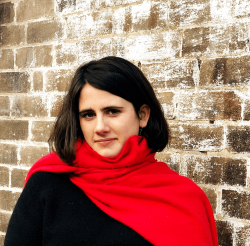 Victoria standing in front of a brick wall