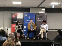 Two students on a stage interviewing Richard