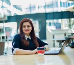 Dr Muneera Mano sitting in front of a computer 01