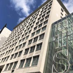 An art deco multi-level building with large glass windows emblazoned with 'UTS'